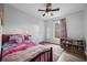 Bright bedroom features hardwood floors, ceiling fan, and a window for natural light at 705 Sunburst Cove Ln, Winter Garden, FL 34787