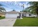 Charming single-story home with a two-car garage, well-manicured lawn, and tropical landscaping at 705 Sunburst Cove Ln, Winter Garden, FL 34787