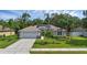 Charming single-story home with well-manicured lawn, palm trees, and two car garage at 705 Sunburst Cove Ln, Winter Garden, FL 34787