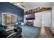Charming living room with guitars, decor, large tv, and blue area rug that creates an inviting ambiance at 705 Sunburst Cove Ln, Winter Garden, FL 34787