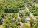 Aerial view of a residential area with homes surrounded by lush trees and vegetation, highlighting the neighborhood's landscape at 710 N Sparkman Ave, Orange City, FL 32763