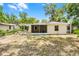 Rear exterior showcasing a backyard, patio, and shade trees at 710 N Sparkman Ave, Orange City, FL 32763
