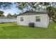 Rear of the house showcases a green lawn and white-painted cinderblock exterior at 7612 Pomelo Dr, Orlando, FL 32819