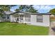 Attractive home with a white exterior, tidy landscaping, and a lush green lawn at 7612 Pomelo Dr, Orlando, FL 32819