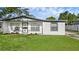 Charming single-story home featuring white exterior paint, gray trim, and a well-manicured lawn at 7612 Pomelo Dr, Orlando, FL 32819