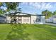 Well-maintained home with a fresh white exterior, landscaping, and a spacious green lawn at 7612 Pomelo Dr, Orlando, FL 32819