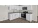 Modern kitchen with white cabinets, stainless steel appliances, and granite countertops at 7612 Pomelo Dr, Orlando, FL 32819