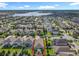 Wide aerial of the property showing the landscaping, neighborhood, and lake in the distance at 8030 John Hancock Dr, Winter Garden, FL 34787
