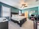 Comfortable bedroom with a dark wood frame bed, neutral walls and carpet, and office space at 8030 John Hancock Dr, Winter Garden, FL 34787