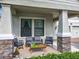 Inviting front porch with stone-clad columns, comfortable seating, and views of the well-maintained front yard and neighborhood at 8030 John Hancock Dr, Winter Garden, FL 34787