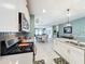 Bright kitchen features white cabinets, stainless steel appliances, quartz countertops, and an open view to the dining area at 8030 John Hancock Dr, Winter Garden, FL 34787