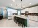Spacious kitchen featuring a large island with bar stools, white cabinets and modern appliances at 8030 John Hancock Dr, Winter Garden, FL 34787