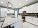 Modern kitchen features white cabinetry, stainless steel appliances, dark backsplash, and a large island with quartz countertops at 8030 John Hancock Dr, Winter Garden, FL 34787