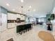 Bright, open kitchen and dining area features white cabinets, an island with bar seating, and a view to the living room at 8030 John Hancock Dr, Winter Garden, FL 34787