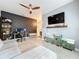 Open-concept living room with gray sectional sofa, wood-look ceiling fan, built-in bookcase, TV, and toy kitchen set at 8030 John Hancock Dr, Winter Garden, FL 34787