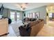 Cozy living room with large sectional sofa, neutral paint, and sliding glass doors to the backyard at 8030 John Hancock Dr, Winter Garden, FL 34787