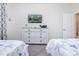 Comfortable bedroom with two twin beds, dresser, and nautical-themed decor at 8982 Cabot Cliffs Dr, Davenport, FL 33896