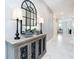 Bright foyer with decorative cabinet, mirror, lamps, marble floors, and neutral wall colors at 8982 Cabot Cliffs Dr, Davenport, FL 33896
