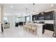 Open kitchen with an island, chairs, stainless steel appliances, and an adjacent dining area and living room at 8982 Cabot Cliffs Dr, Davenport, FL 33896