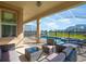 Relaxing covered patio with comfortable seating overlooking the screened-in pool and stunning water views at 8982 Cabot Cliffs Dr, Davenport, FL 33896