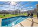 Refreshing screened-in pool and spa area with comfortable lounge chairs and backyard views at 8982 Cabot Cliffs Dr, Davenport, FL 33896
