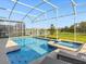 Backyard pool and spa area with a screened enclosure and views of the water at 8982 Cabot Cliffs Dr, Davenport, FL 33896