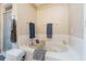 Well-lit bathroom features a large soaking tub with a convenient caddy and separate shower with glass doors at 929 Louvre Ct, Kissimmee, FL 34759