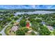 Expansive aerial view showcasing the home's location near a lake and surrounded by lush greenery and mature trees at 10697 Lake Hill Dr, Clermont, FL 34711