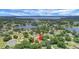 Picturesque aerial shot of the property nestled among lush trees, near a lake, showcasing its serene location at 10697 Lake Hill Dr, Clermont, FL 34711