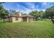 View of the home's exterior featuring a well-maintained lawn and a screened-in patio at 10697 Lake Hill Dr, Clermont, FL 34711