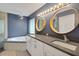 Modern bathroom boasts dual sinks, granite countertops, large mirrors, and a soaking tub at 10697 Lake Hill Dr, Clermont, FL 34711