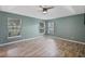 Spacious bedroom featuring ceiling fan, wood floors, and three windows, offering plenty of natural light at 10697 Lake Hill Dr, Clermont, FL 34711
