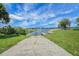 Concrete boat ramp leading to the lake with docks and lush green grass surrounding it at 10697 Lake Hill Dr, Clermont, FL 34711