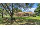 Well-maintained single-story home featuring a lush front lawn and mature trees at 10697 Lake Hill Dr, Clermont, FL 34711