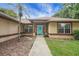 Inviting home with a light blue front door, manicured landscaping, and large windows at 10697 Lake Hill Dr, Clermont, FL 34711