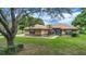 Well-maintained single-story home with lush front lawn and mature tree providing shade at 10697 Lake Hill Dr, Clermont, FL 34711