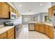 Well-lit kitchen with wood cabinets, stainless steel appliances, and tile flooring at 10697 Lake Hill Dr, Clermont, FL 34711