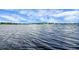 Calm lake view extends to the horizon under a partly cloudy blue sky at 10697 Lake Hill Dr, Clermont, FL 34711