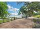 Scenic lakeside path with benches, railing, and lush green trees at 10697 Lake Hill Dr, Clermont, FL 34711