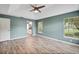 A spacious bedroom features hardwood floors, windows, a ceiling fan, and an attached bathroom at 10697 Lake Hill Dr, Clermont, FL 34711