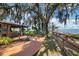 Charming outdoor bar and patio area with lush trees, Spanish moss, and views of the lake at 10697 Lake Hill Dr, Clermont, FL 34711