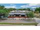 Charming outdoor seating area at Suncreek Cafe and Brewery, with orange tables and umbrellas overlooking a scenic lake at 10697 Lake Hill Dr, Clermont, FL 34711