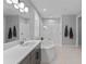 Serene bathroom with dual sinks, a soaking tub, a glass-enclosed shower, and modern fixtures for a luxurious experience at 1224 Hillcrest View Loop, Apopka, FL 32703
