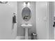 Charming powder room with a pedestal sink, a mirror, and decor at 1224 Hillcrest View Loop, Apopka, FL 32703