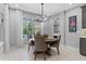Bright dining area featuring a round wooden table, chandelier, and scenic views from a large window at 1224 Hillcrest View Loop, Apopka, FL 32703