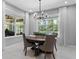Bright dining area with natural light showcasing a round wooden table, neutral-toned chairs, and views of the outdoor space at 1224 Hillcrest View Loop, Apopka, FL 32703