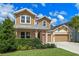 Beautiful two-story home featuring a three-car garage, manicured lawn, and inviting covered front porch at 1224 Hillcrest View Loop, Apopka, FL 32703