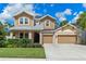 Beautiful two-story home featuring a manicured lawn, three-car garage, and tasteful curb appeal at 1224 Hillcrest View Loop, Apopka, FL 32703