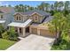 Attractive two-story home featuring a three-car garage, manicured landscaping, and covered front porch at 1224 Hillcrest View Loop, Apopka, FL 32703