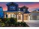 Charming two-story home with well-manicured landscaping and welcoming front porch at dusk at 1224 Hillcrest View Loop, Apopka, FL 32703